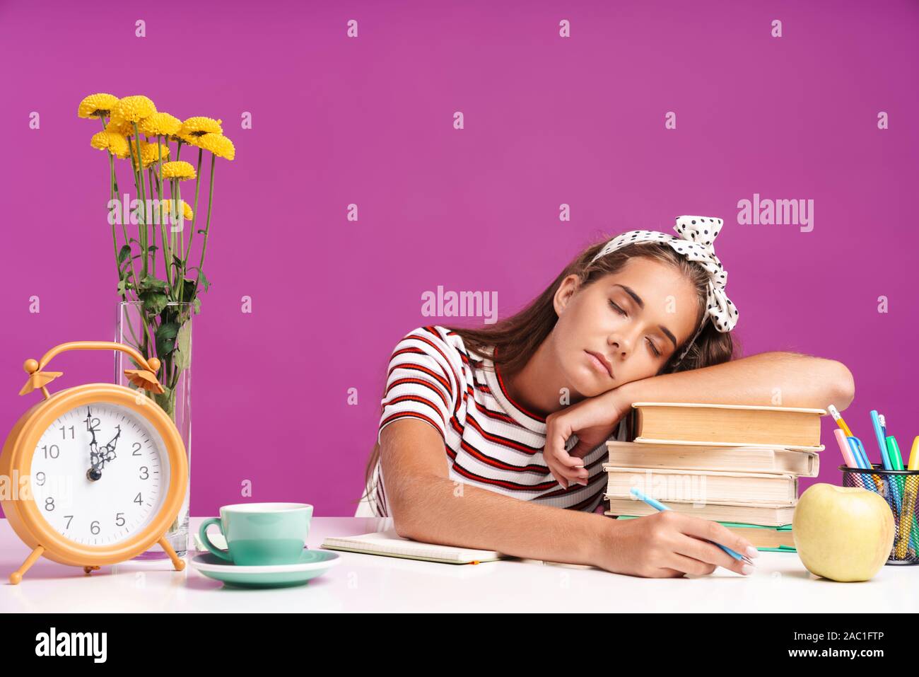 Attractive Tired Sleepy Young Girl Sitting At The Desk Isolated