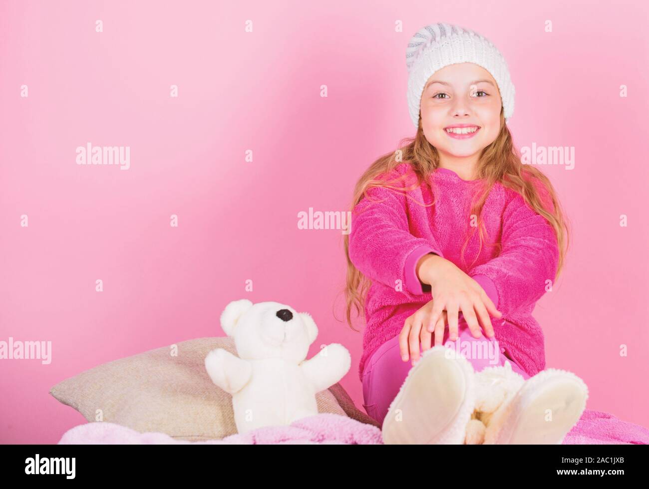 Kid cute girl play with soft toy teddy bear pink background. Teddy bears improve psychological