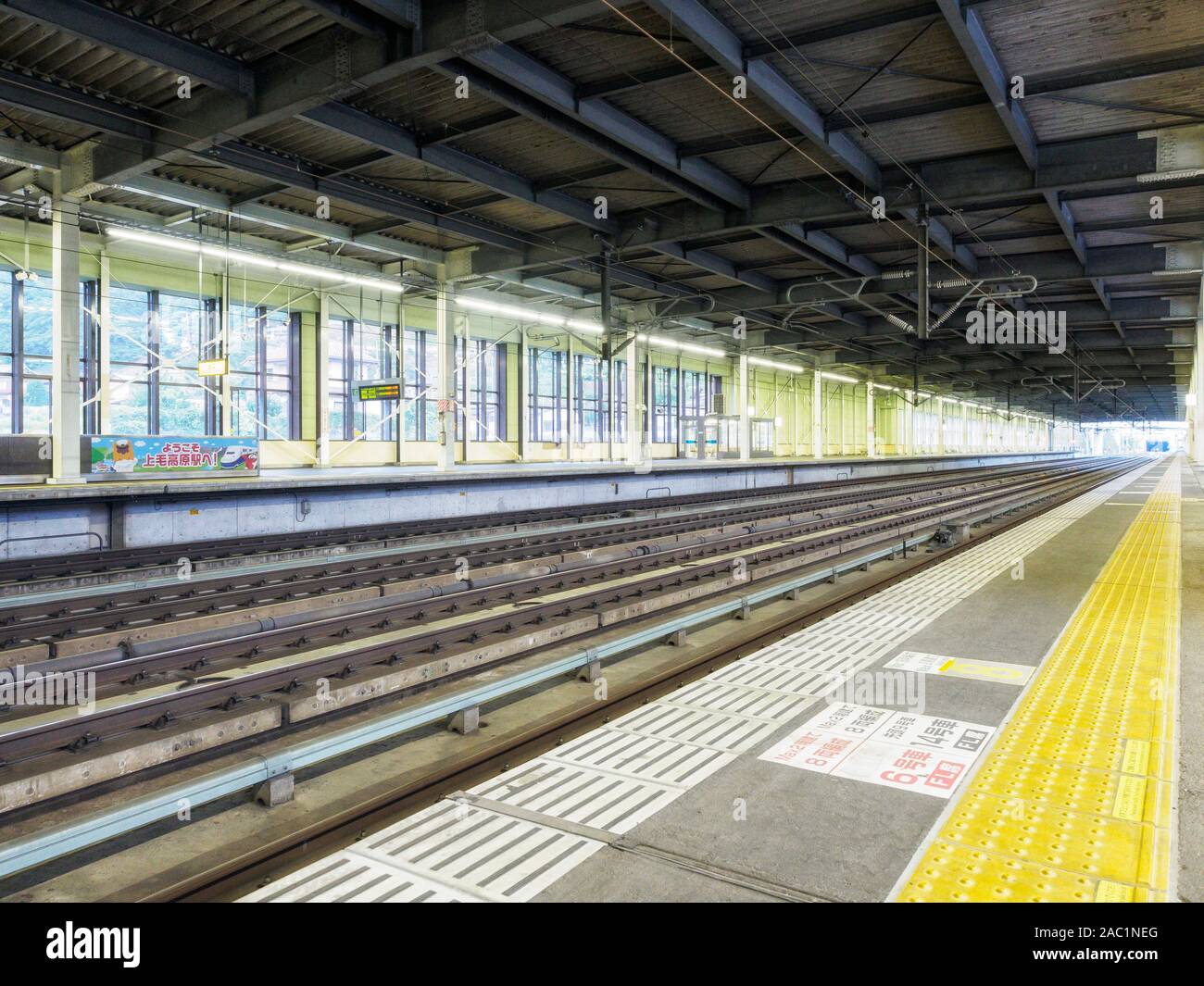 Railway station and platform in Japan, with yellow warning blocks for