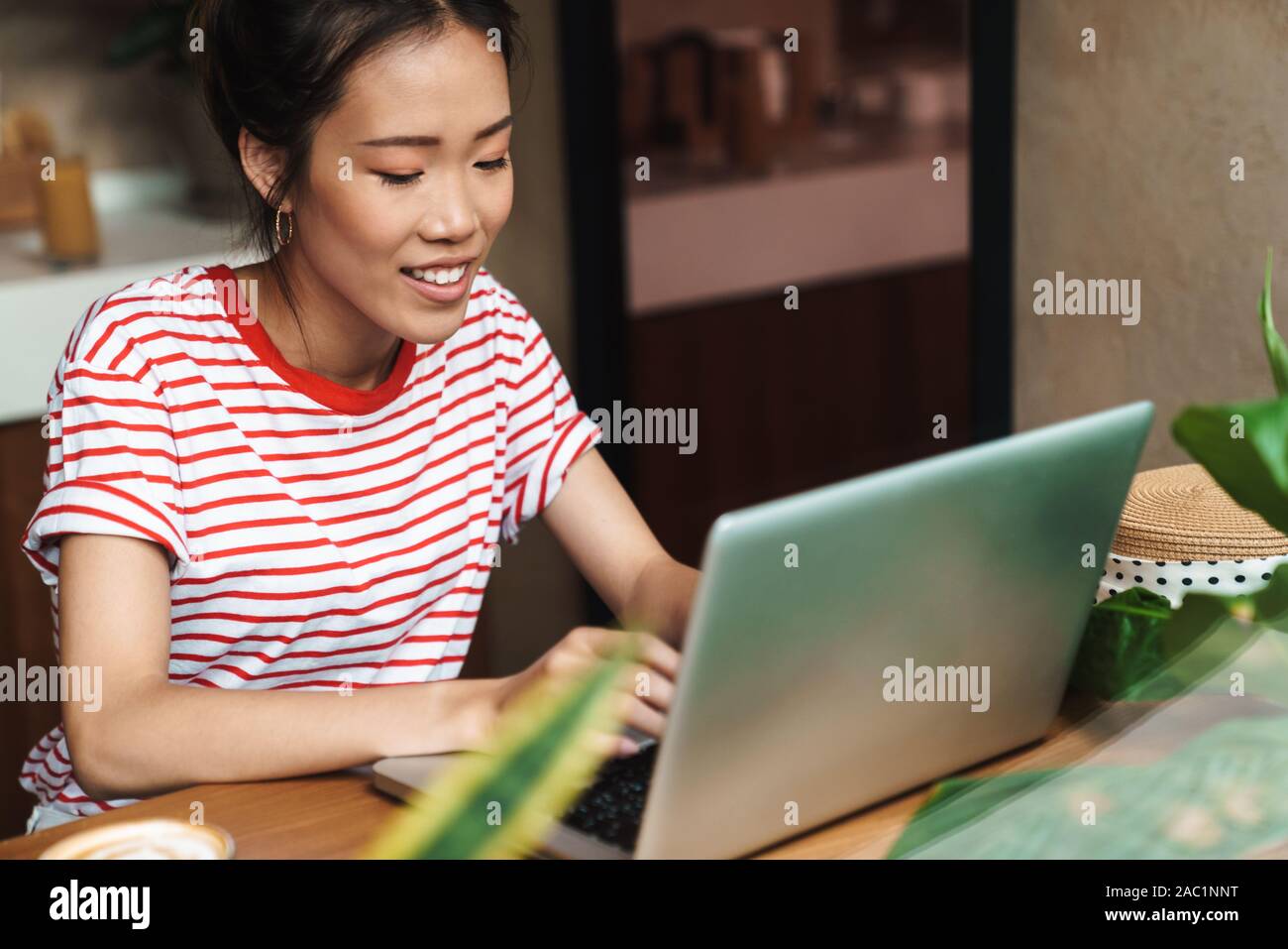 Portrait of happy asian woman using laptop computer while sitting in ...