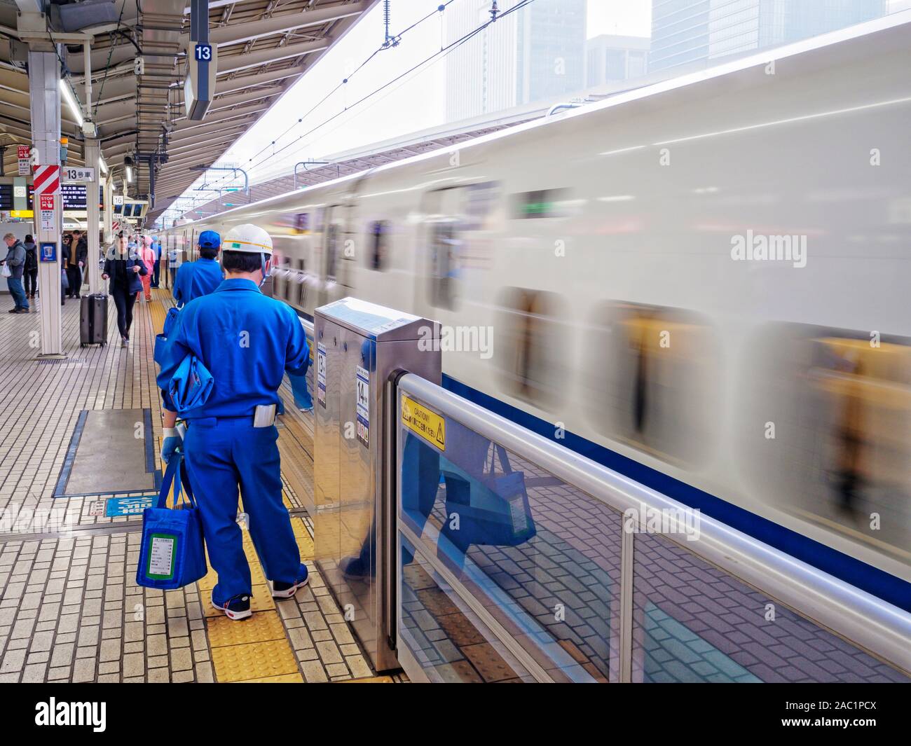 Shinkansen (Bullet Train) arriving at Tokyo Station, with cleaners waiting to clean the train. Stock Photo