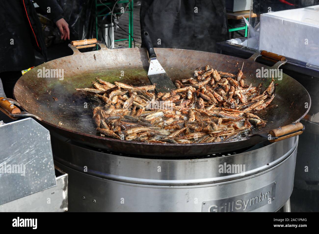 Fried vendace - traditional Finnish finger food - on large frying pan at Baltic Herring Fair in Helsinki Market Square, Finland Stock Photo