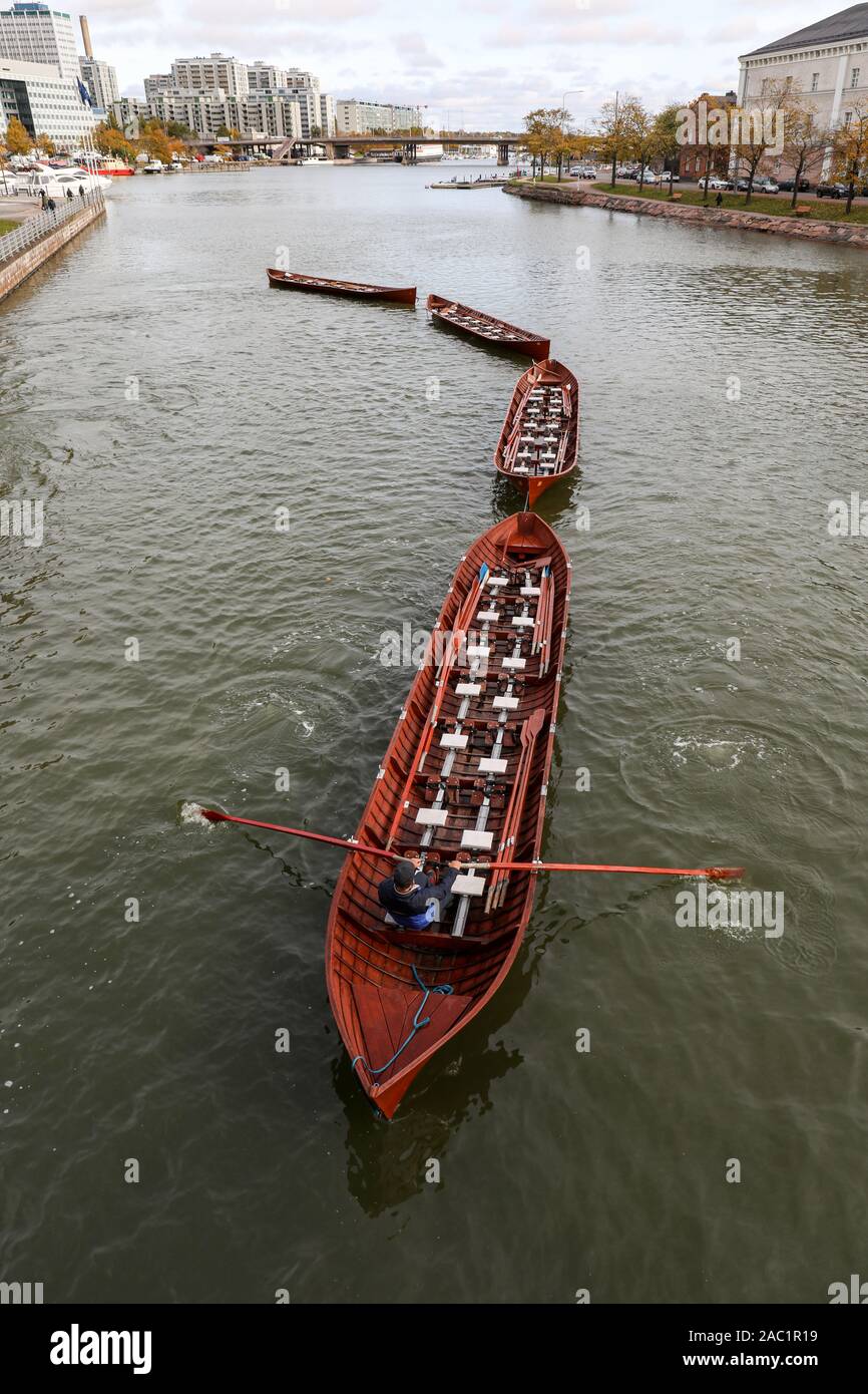 One man rowing four lined church boats in Helsinki, Finland Stock Photo