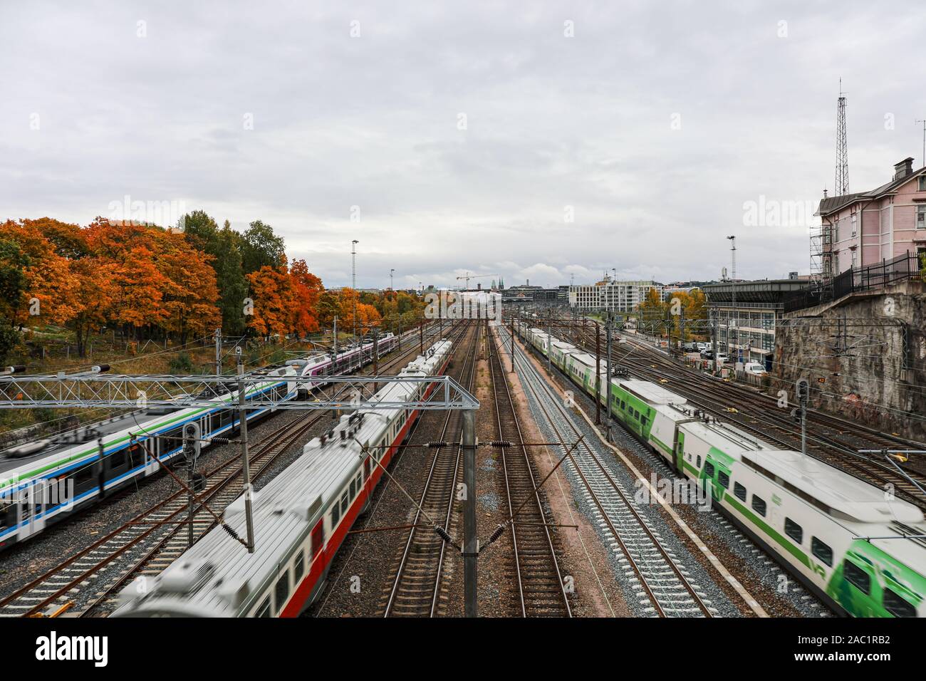 Passenger trains on blurry motion under Linnunlaulu Bridge in Helsinki, Finland Stock Photo
