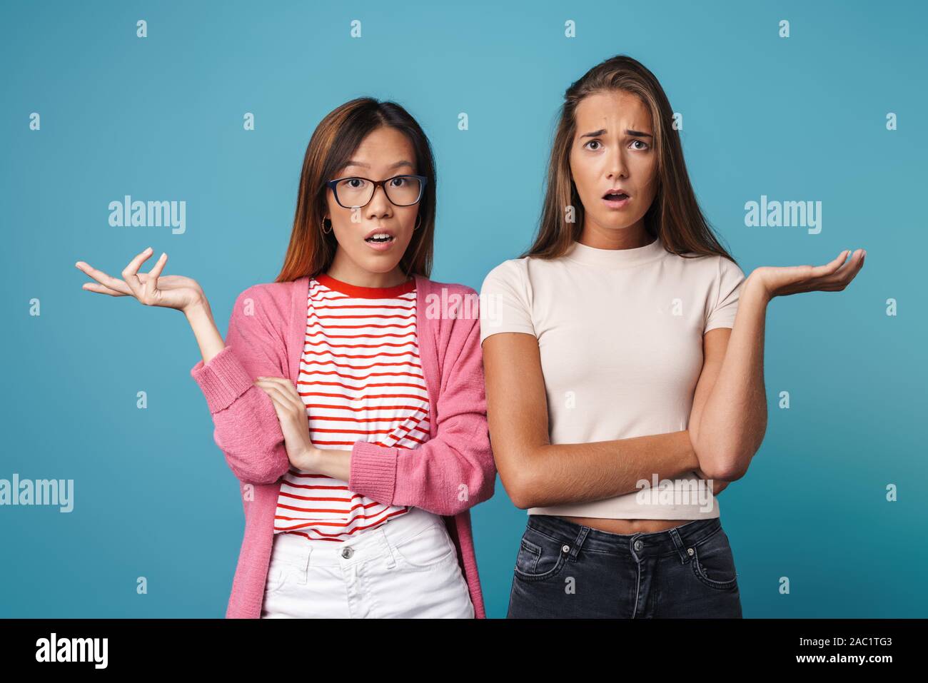 Portrait of multinational confused women posing and looking at camera ...