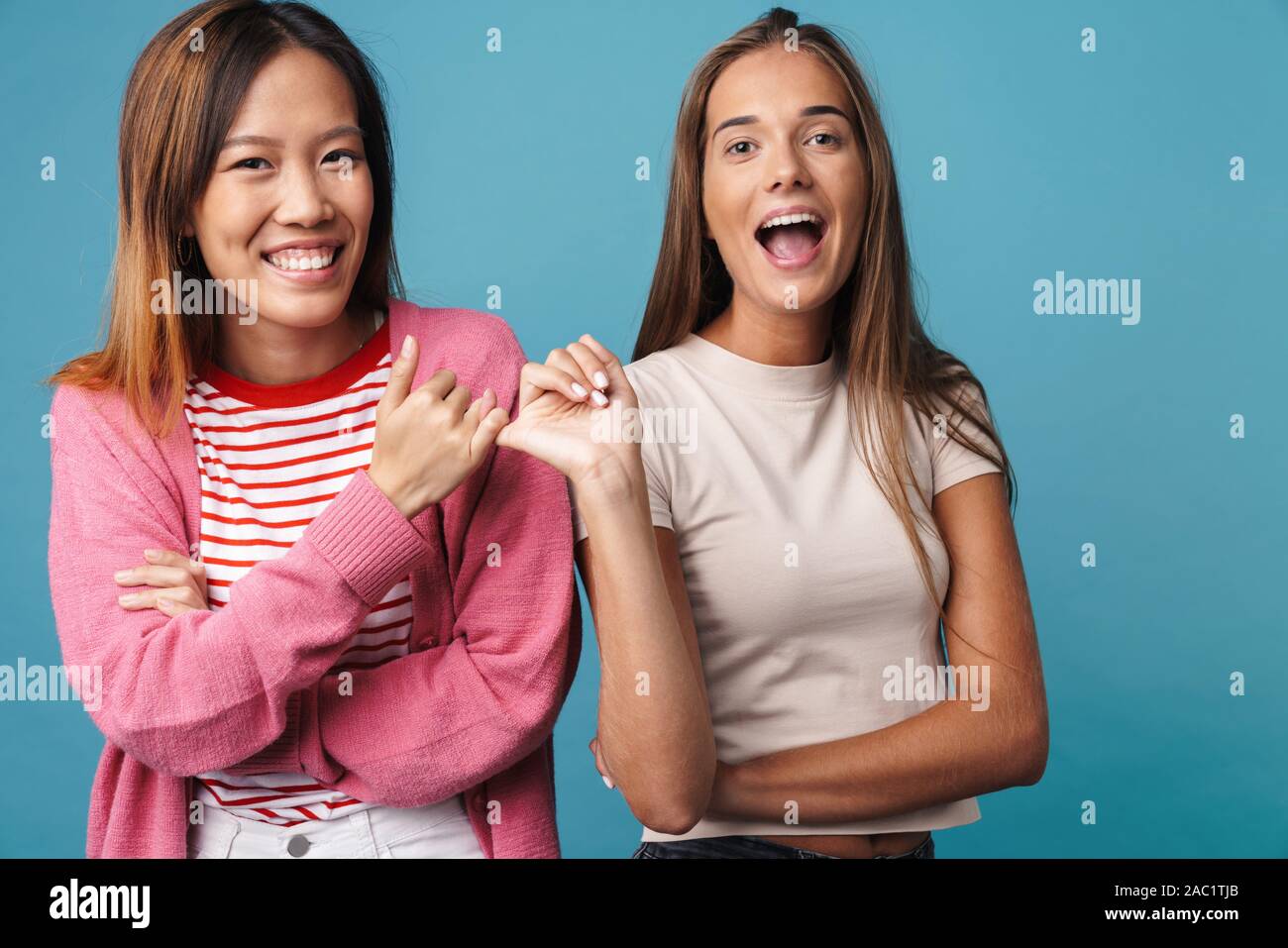 Portrait of multinational joyful women laughing and making peace ...