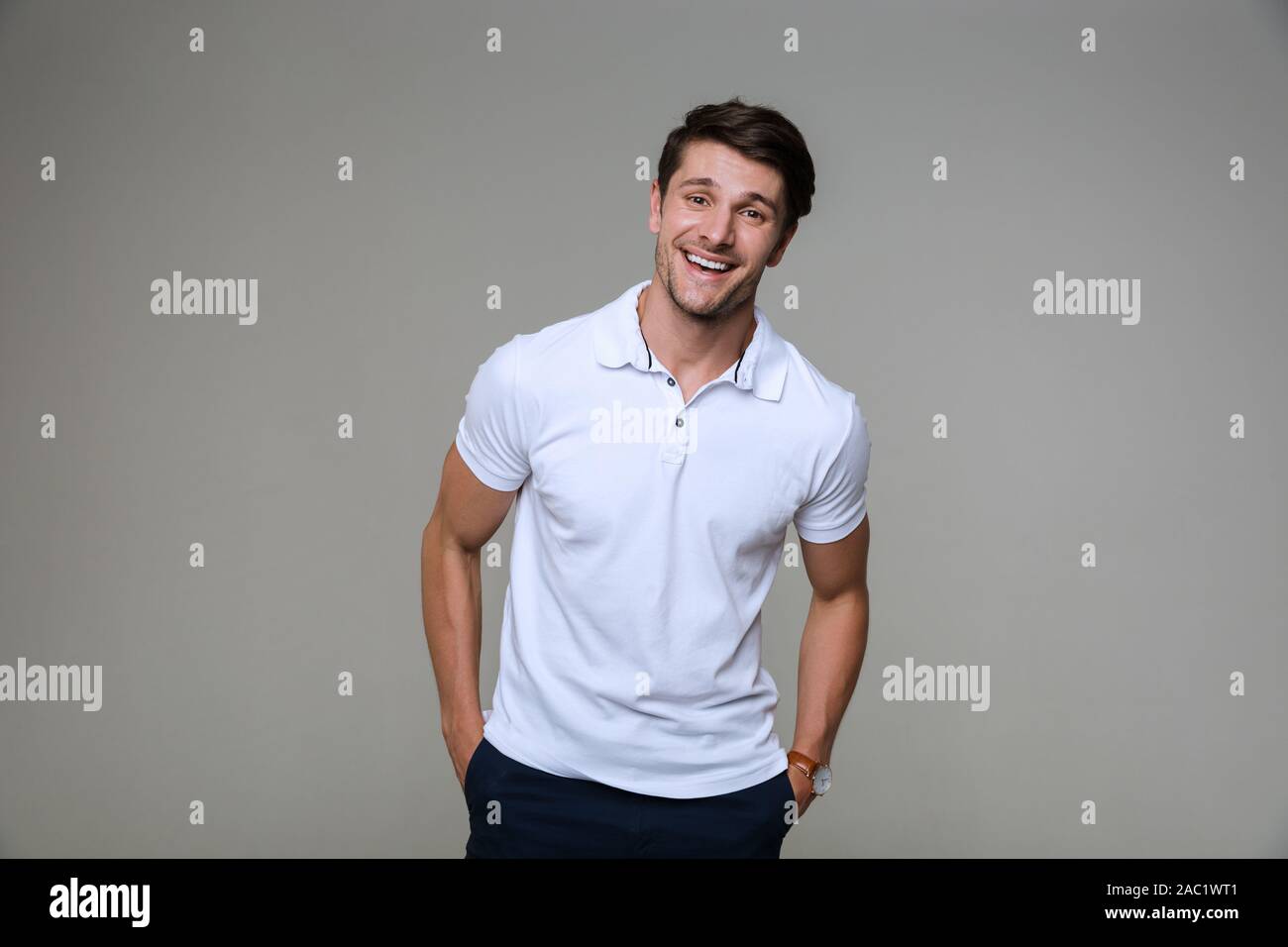 Image of a happy positive handsome young man posing isolated over grey ...