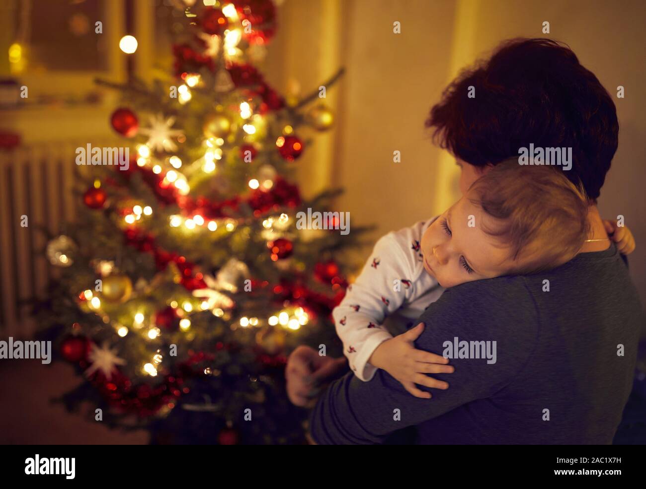 Mother and baby Enjoying in front of beautiful decorated  Christmas tree Stock Photo