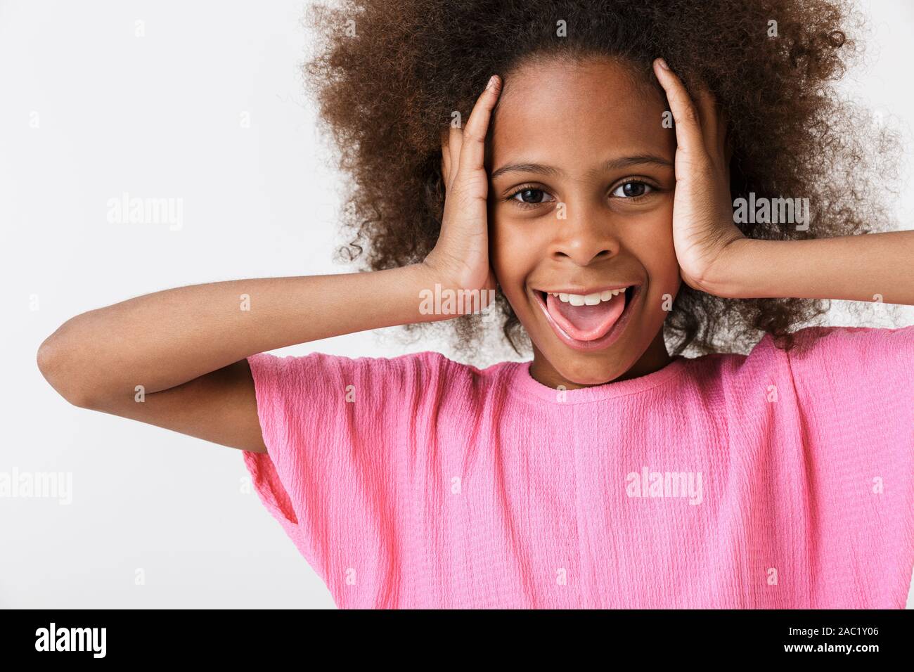 Cheerful funny little african girl wearing pink blouse standing