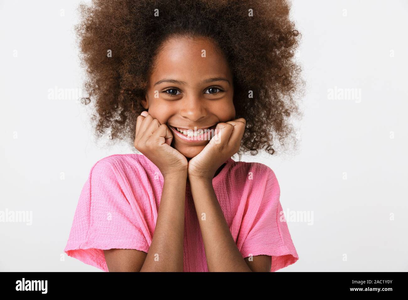 Cheerful funny little african girl wearing blouse standing isolated