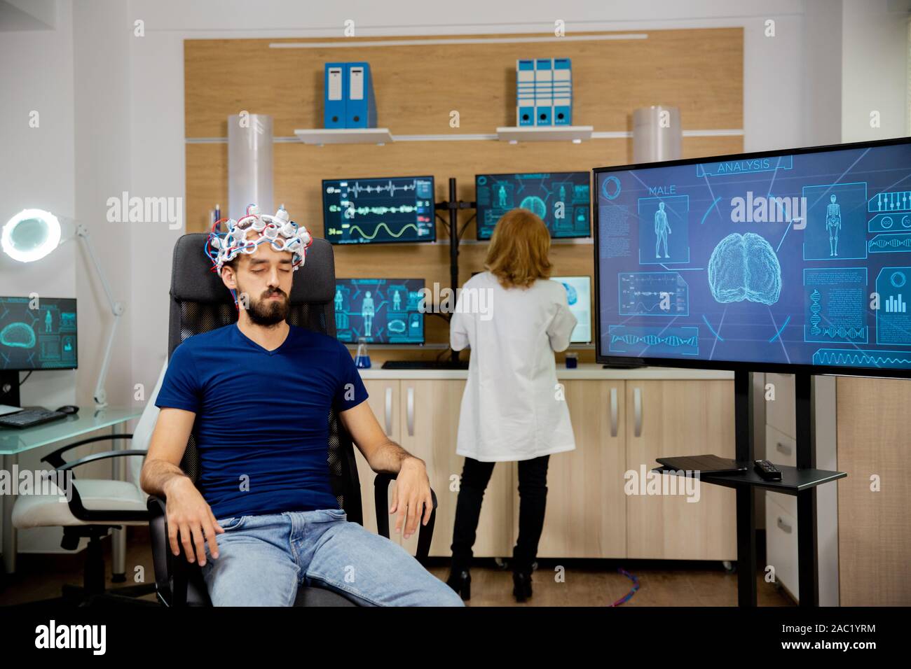 Male patient undergoing a brain scan procedure in the laboratory. Brain waves scanning helmet Stock Photo