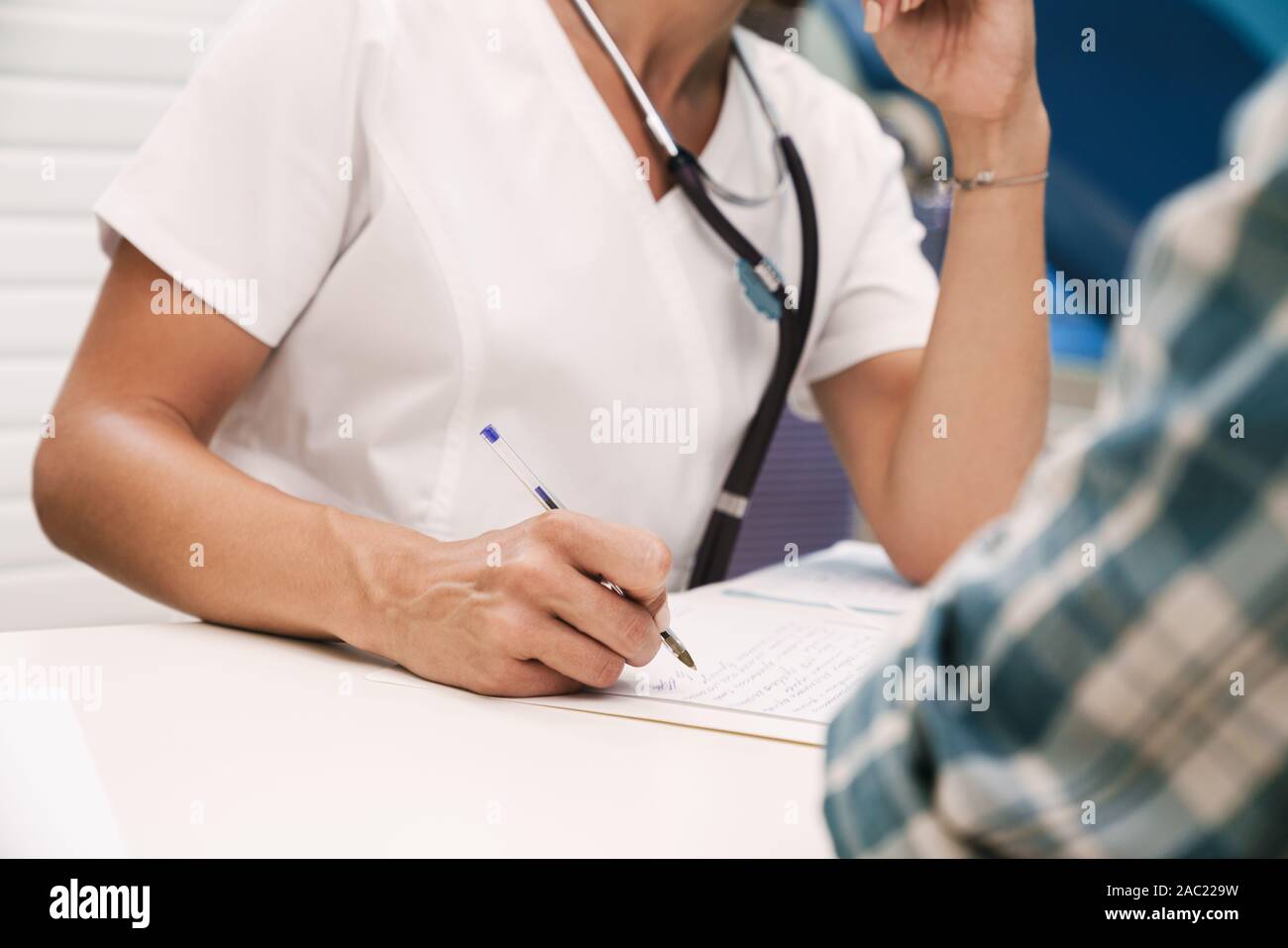 Cropped photo of doctor writing the recipe for patient in hospital at ...