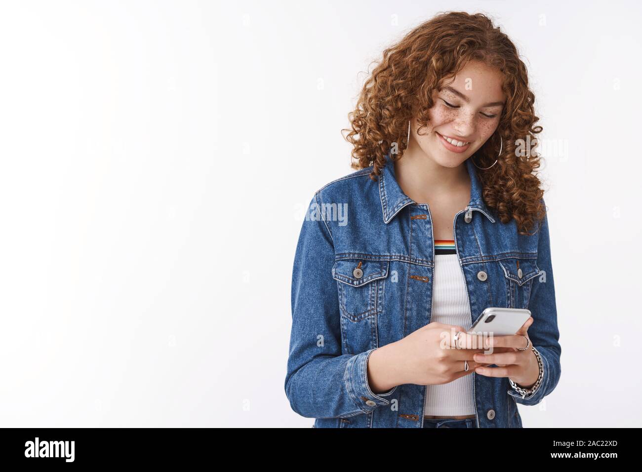 Premium Photo  Happy outgoing stylish ginger adolescent girl curly-haired  pimples holding smartphone playing phone game use funny app look you  devious joyfully smiling messaging talking you same time