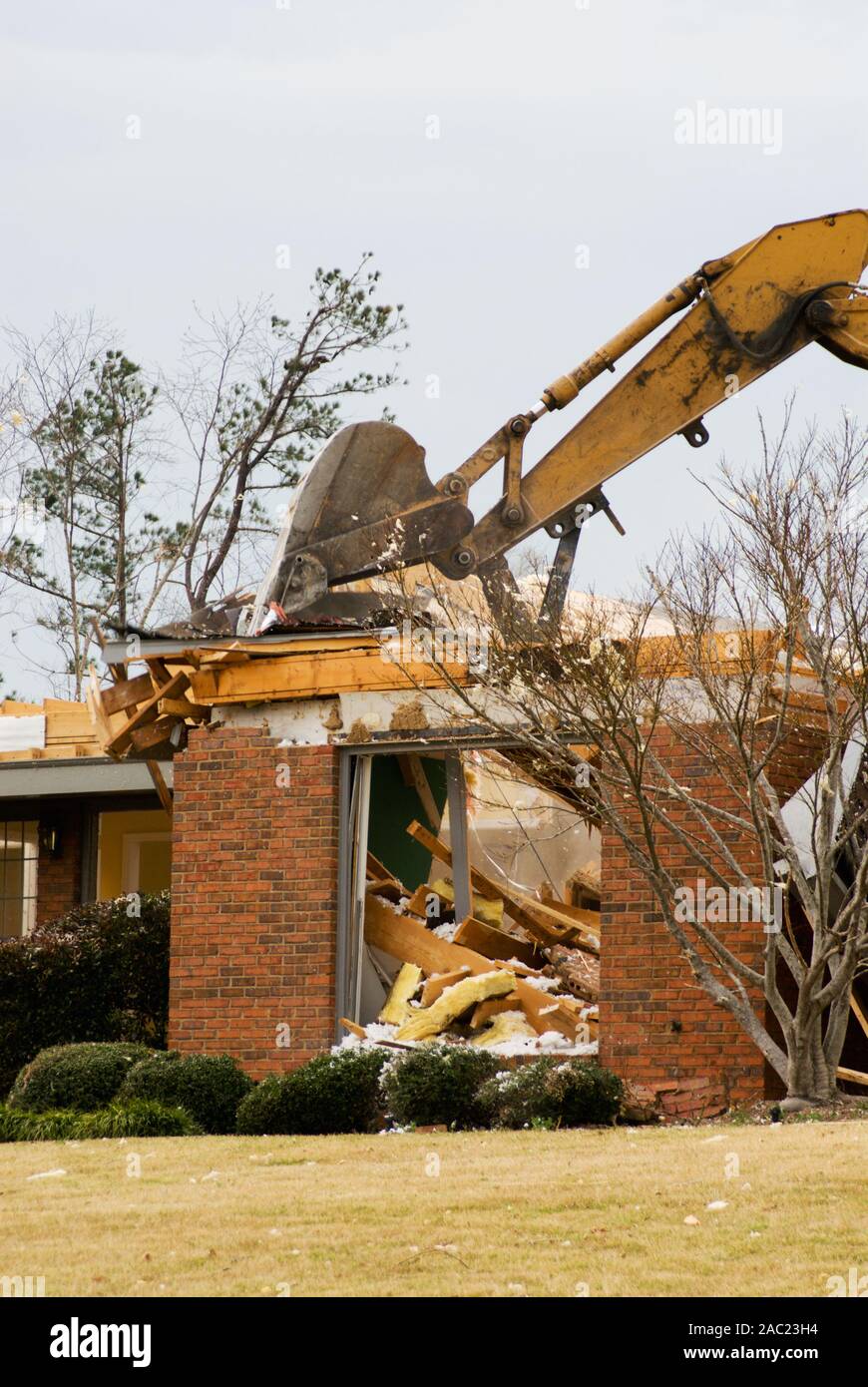 Tornado destroyed house is being demolished with an excavator. Stock Photo