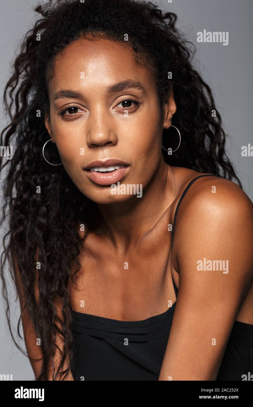 Portrait of an attractive young african woman with long curly hair ...