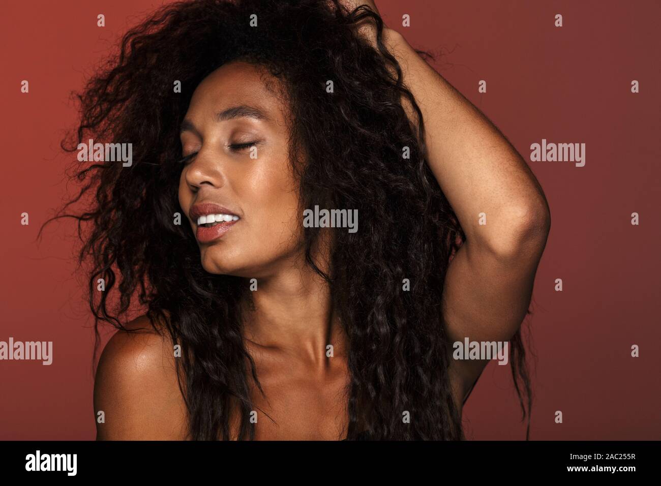 Portrait of an attractive young african woman with long curly hair ...
