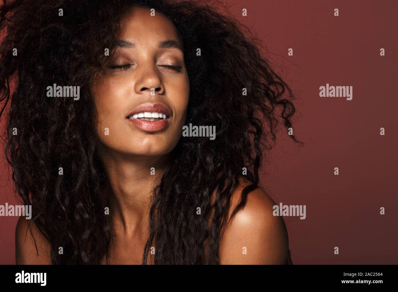 Portrait of an attractive young african woman with long curly hair ...