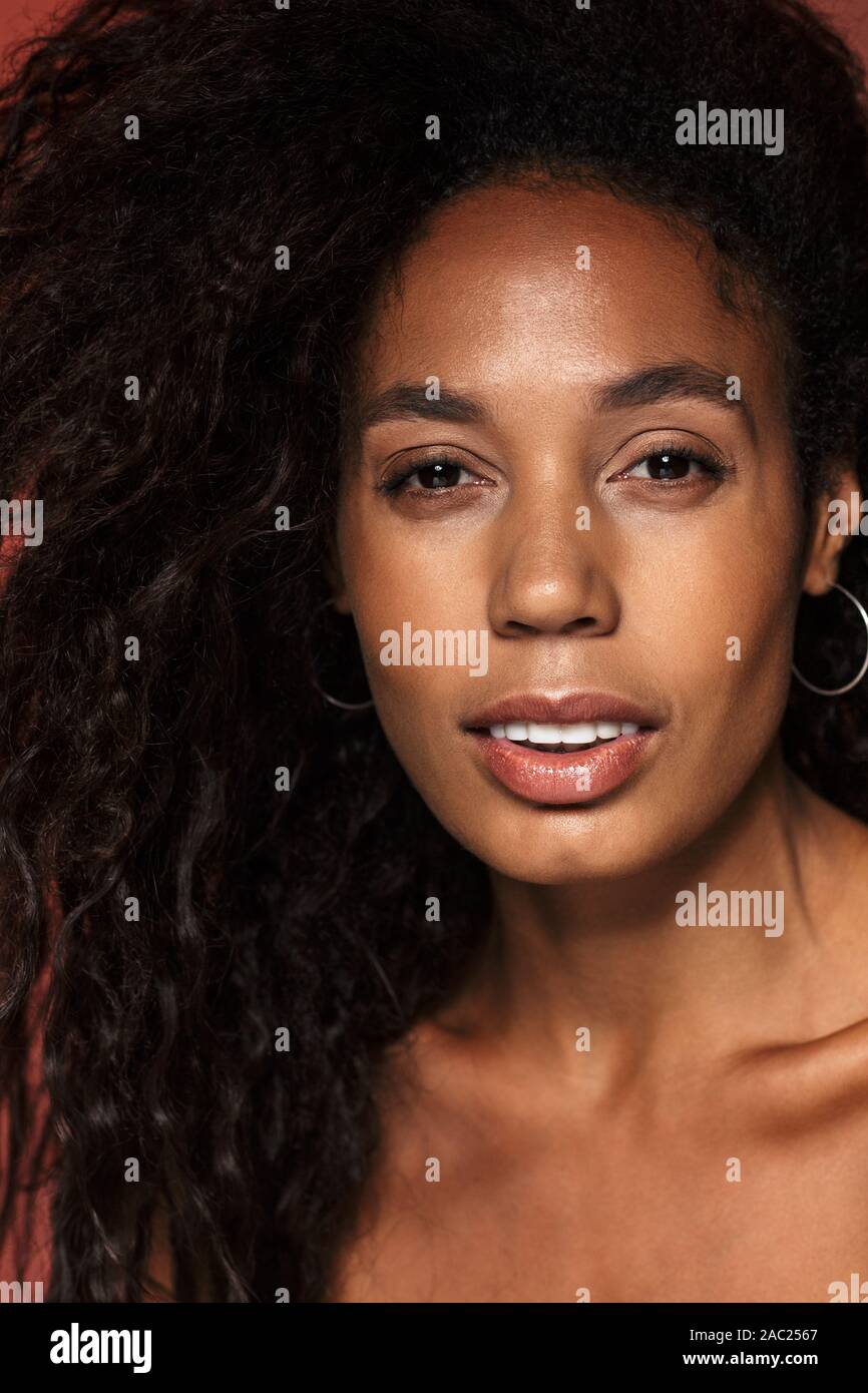 Portrait of an attractive young african woman with long curly hair ...