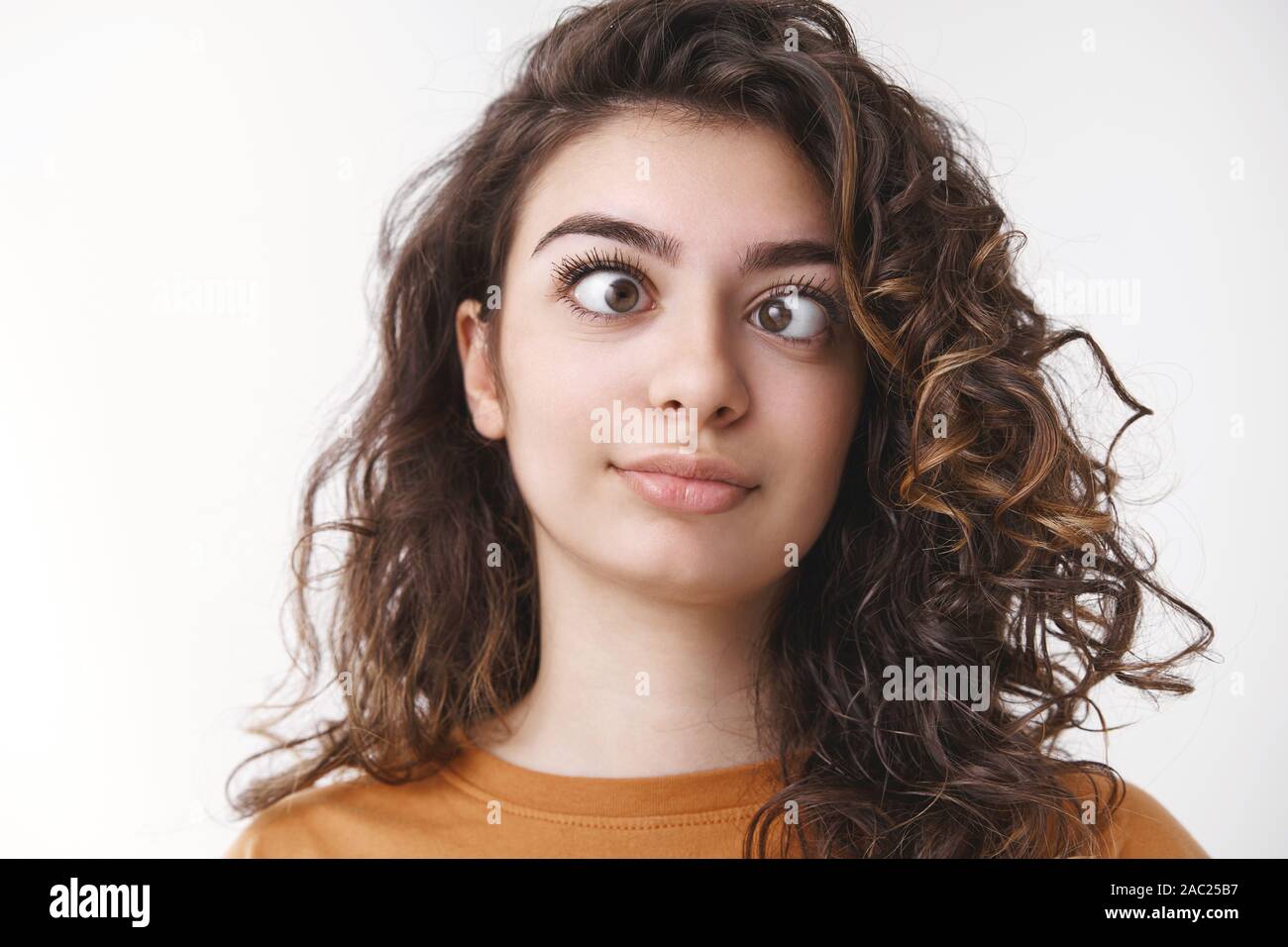 Girl feel bored acting weird fool around squinting eyes different sides make funny grimaces mimick, standing white background crazy head gonna blow up Stock Photo