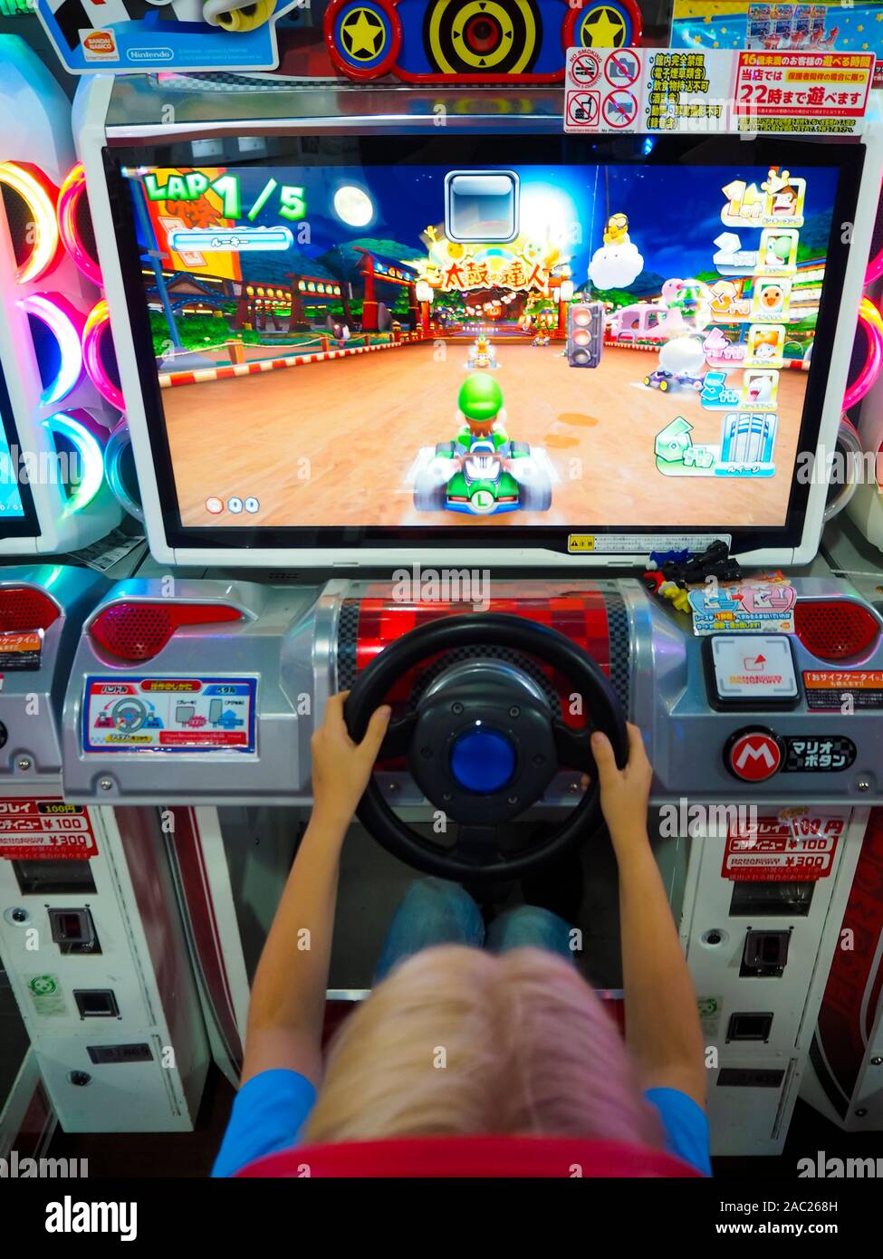 Tokyo, Japan - 12 Oct 2018: A boy is playing a Mario Cart video game at an amusement arcade in Tokyo, Japan. Stock Photo