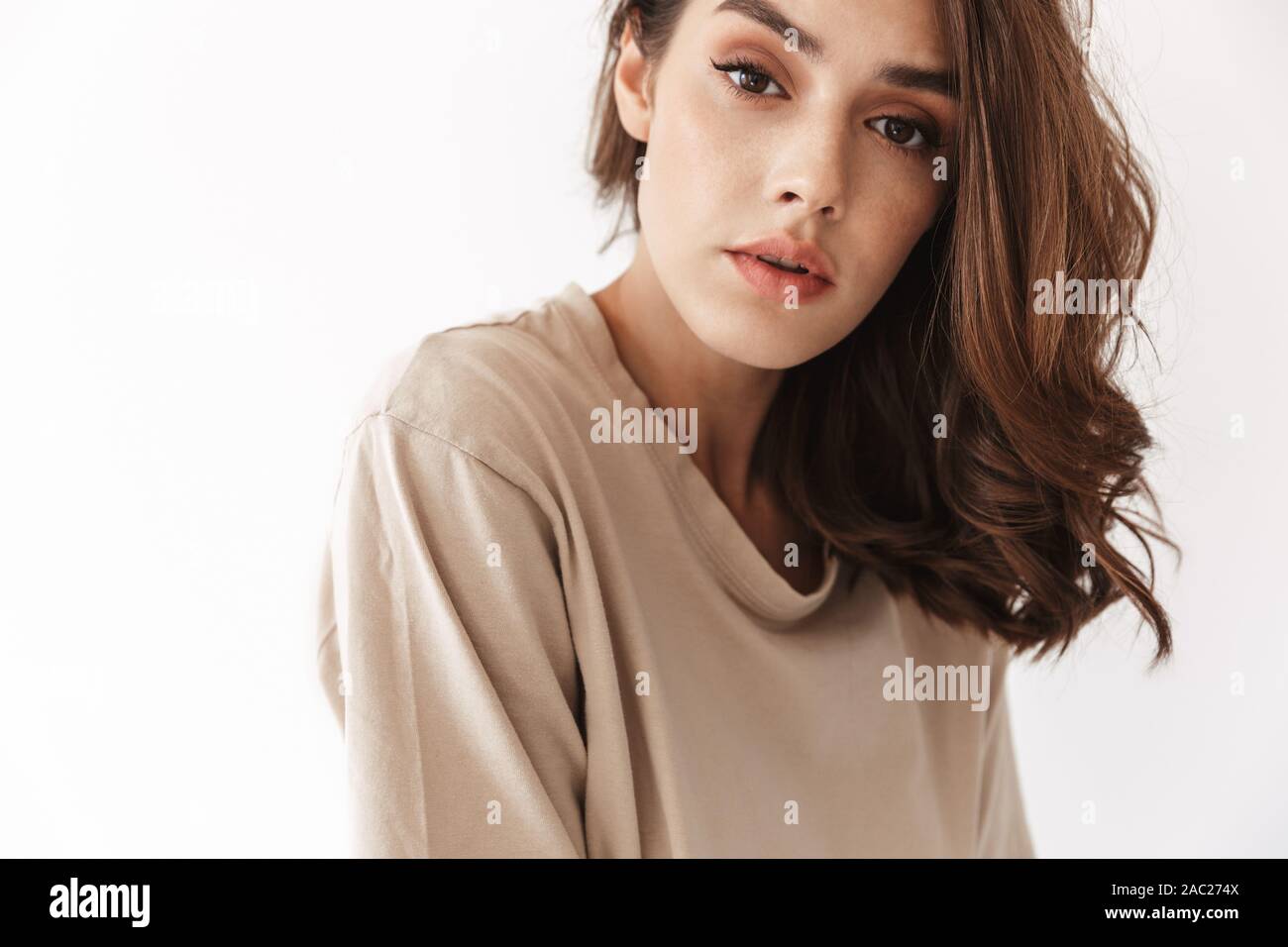 Photo of young beautiful woman posing indoors isolated over white wall ...