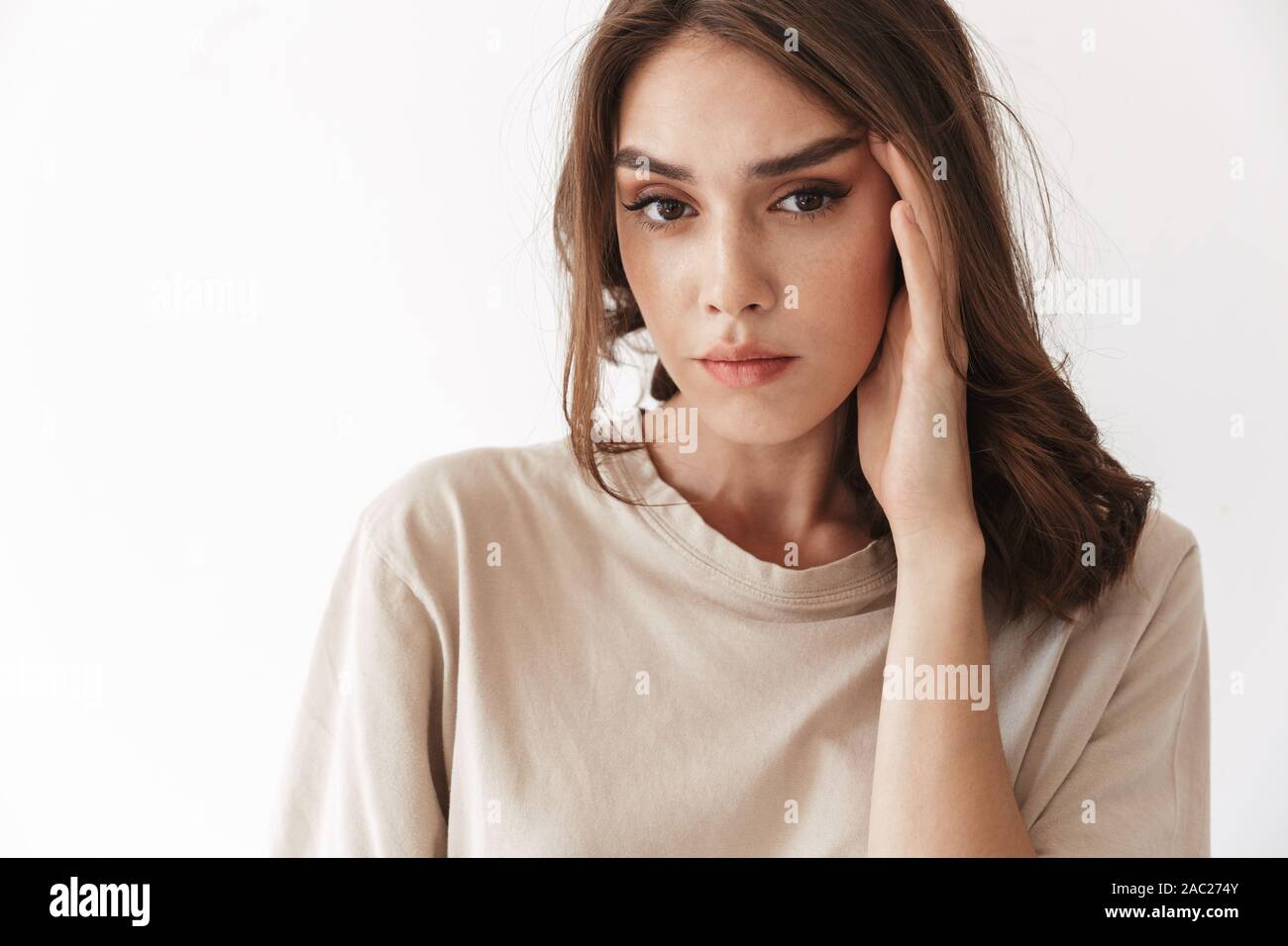 Photo of young beautiful woman posing indoors isolated over white wall ...