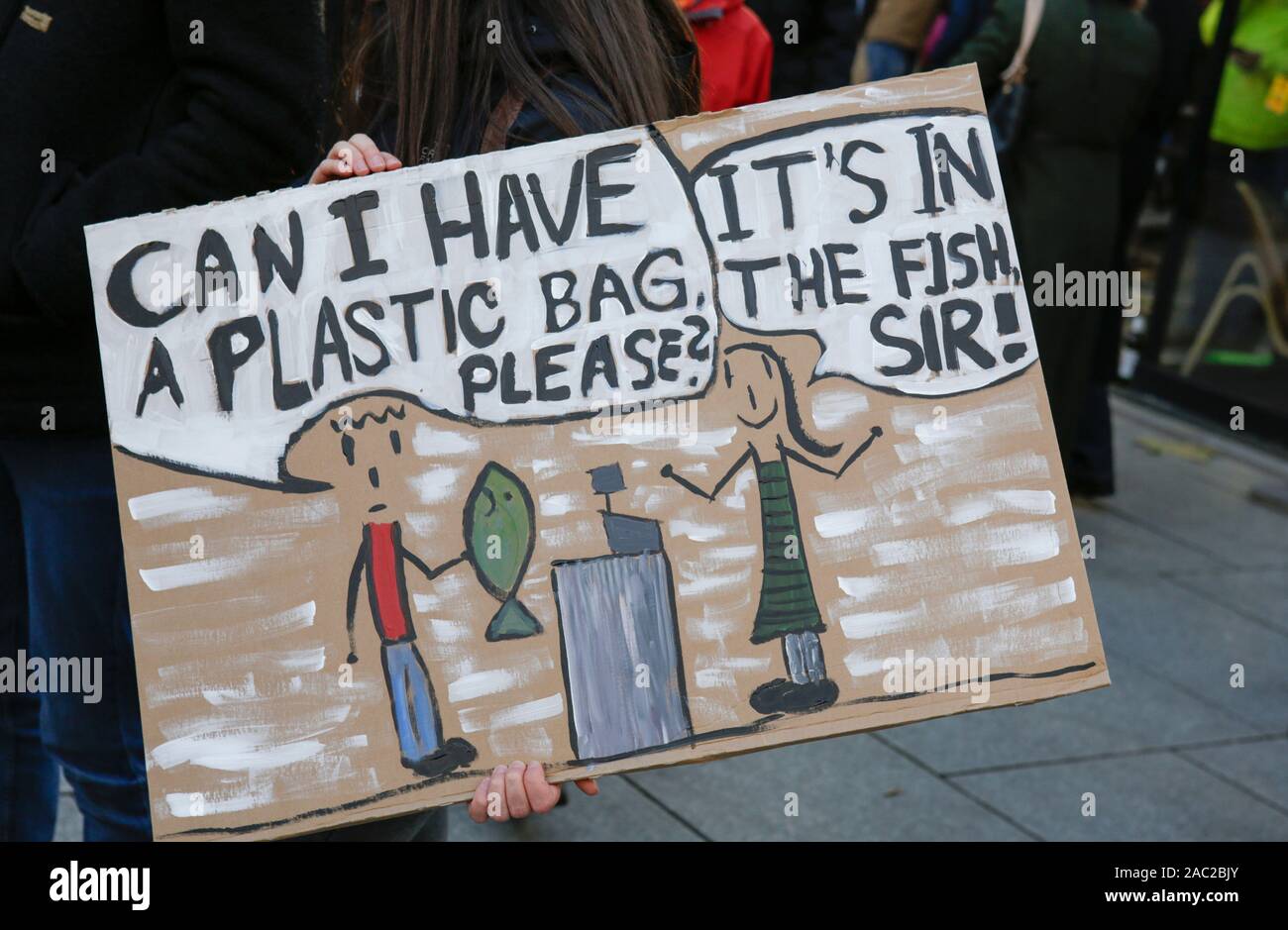 Frankfurt, Germany. 29th Nov, 2019. A protester holds a sign that reads 'Can  I have a plastic bag please? - It's in the fish Sir'. Over 9,000 young  people marched through Frankfurt