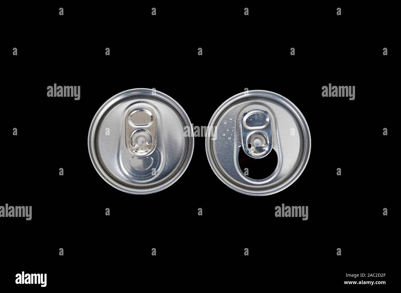 Cans. Top view of an unopened and opened metal can on dark background. Stock Photo