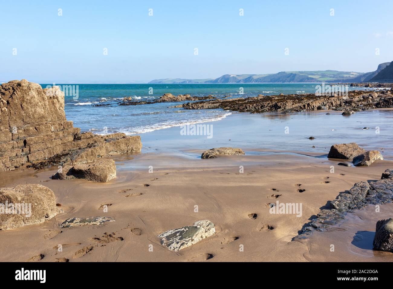 Buck's Mills beach in North Devon, England. The gap in the rocks was man made and called 'The Gut' to create a harbour. Stock Photo