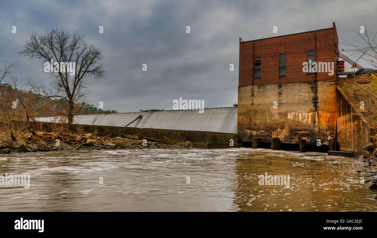 Power plant and damn on river with bare tree in Saxapahaw North