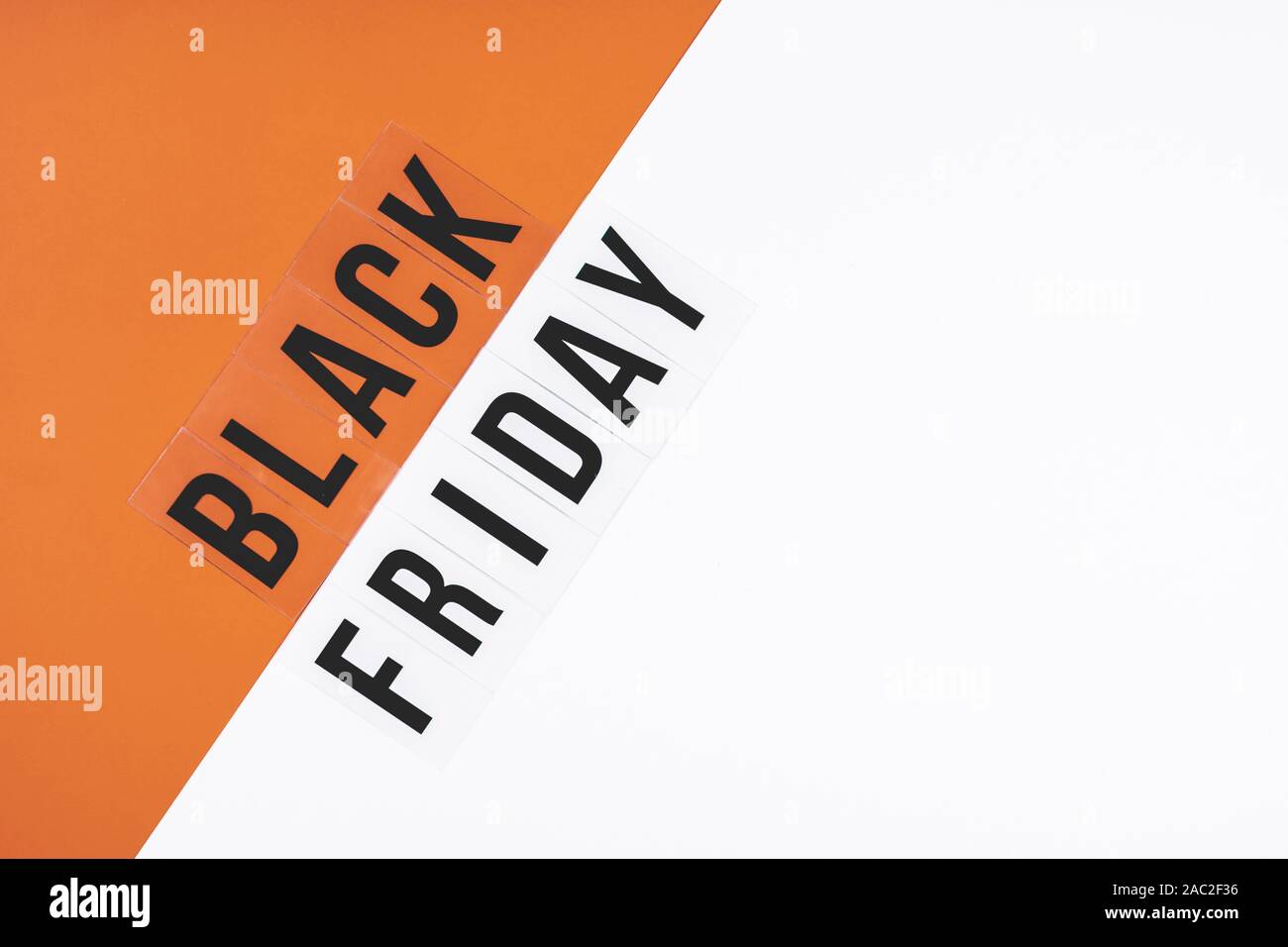 The inscription in black letters BLACK FRIDAY on a gray orange background Stock Photo