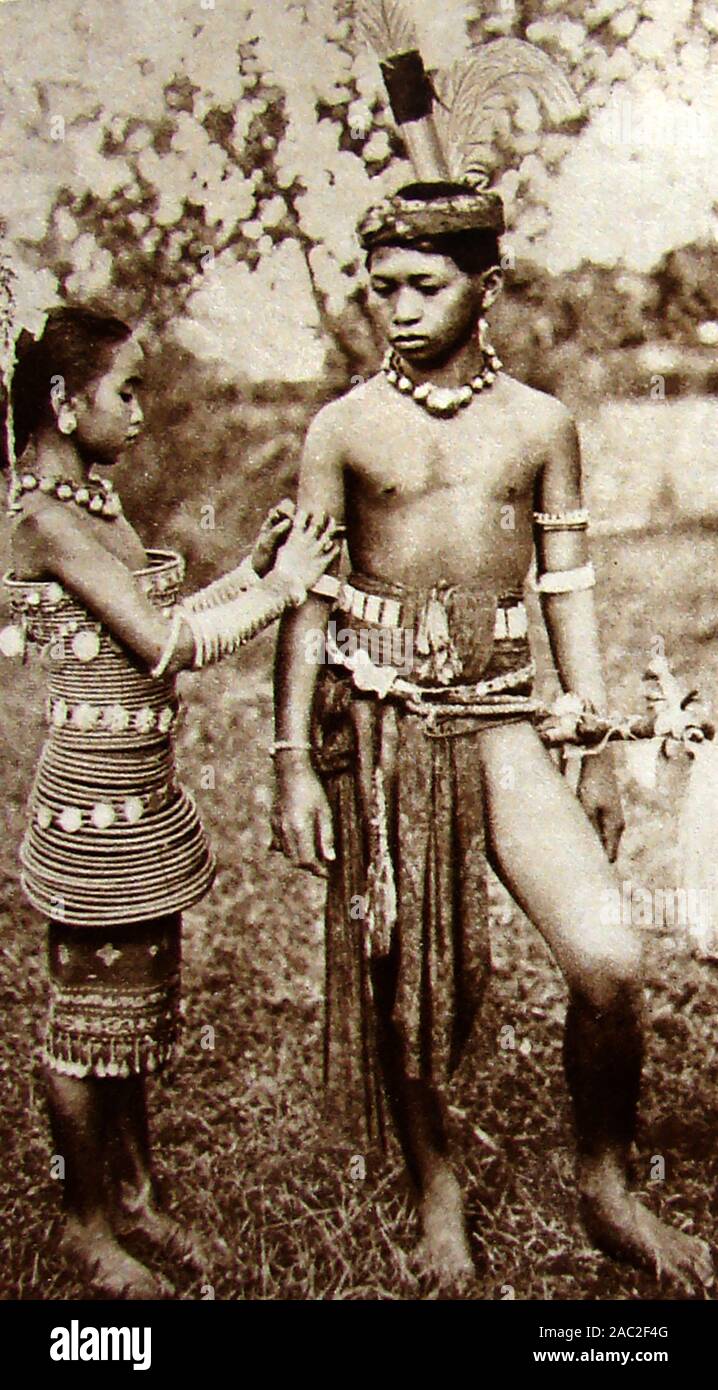 1930's vintage photograph of two children from the Dyak (aka Dayuh)  native tribe people of Borneo (Iban or Sea Dajak boy and girl in traditional dress) Stock Photo