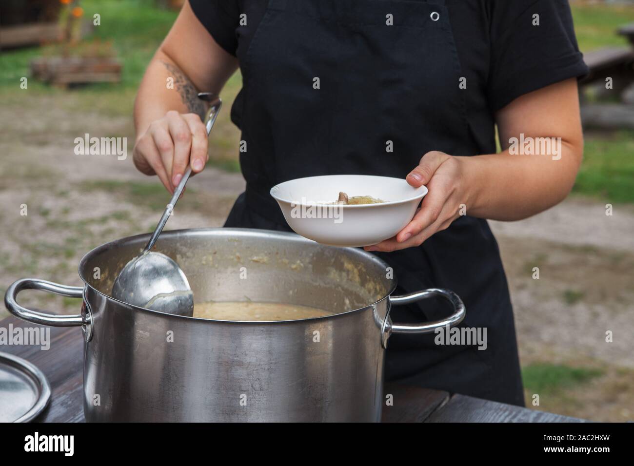 https://c8.alamy.com/comp/2AC2HXW/woman-serving-soup-outside-picnic-2AC2HXW.jpg