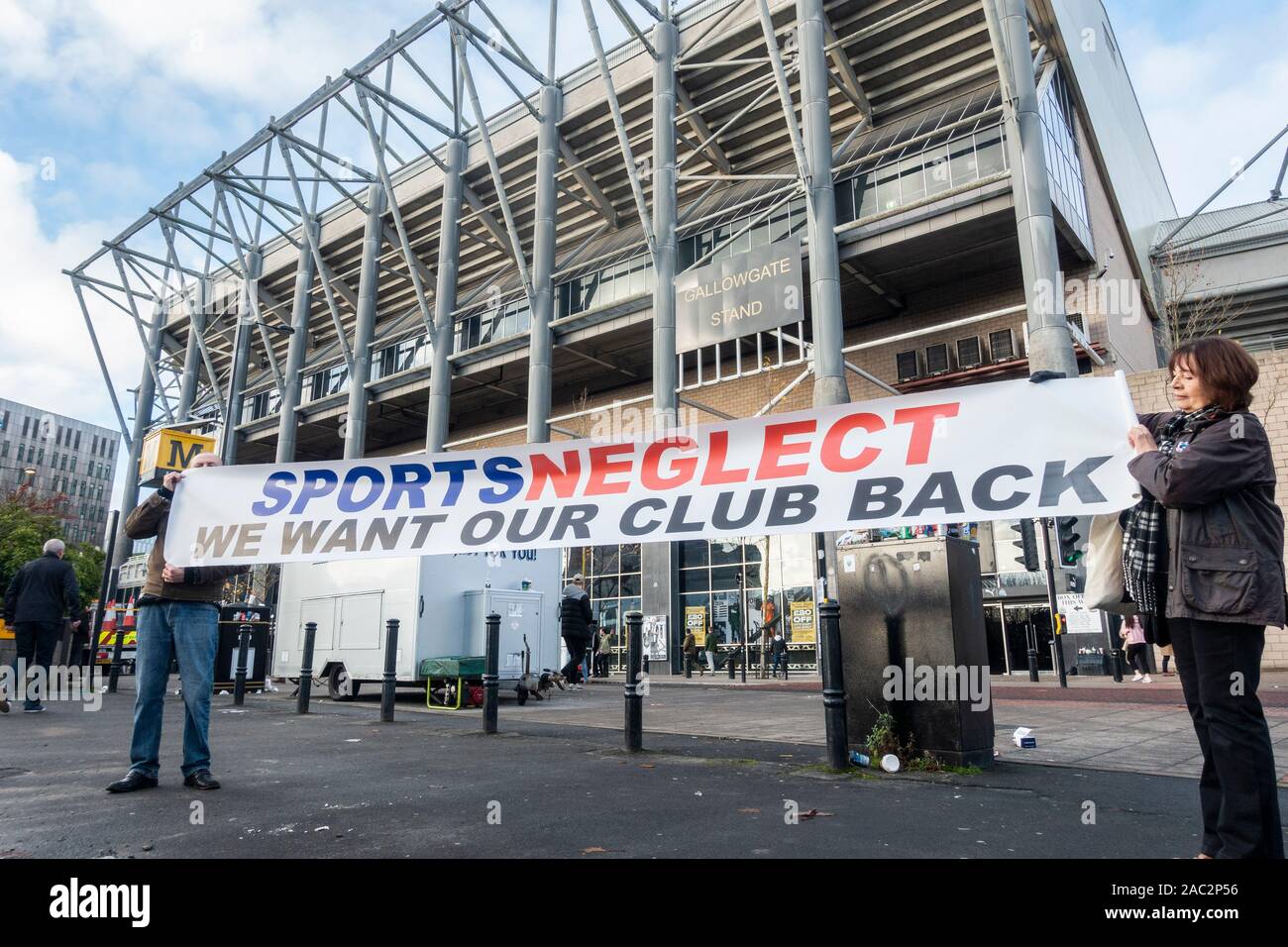 Newcastle, England, UK. 30th November, 2019. Members of The Magpie Group, a group opposed to the club's owner, Mike Ashley, (owner of Sports Direct), hold a 'Sports Neglect' banner outside St James' Park ahead of Newcastle's home game against Manchester City. Credit: Alan Dawson /Alamy Live News Stock Photo
