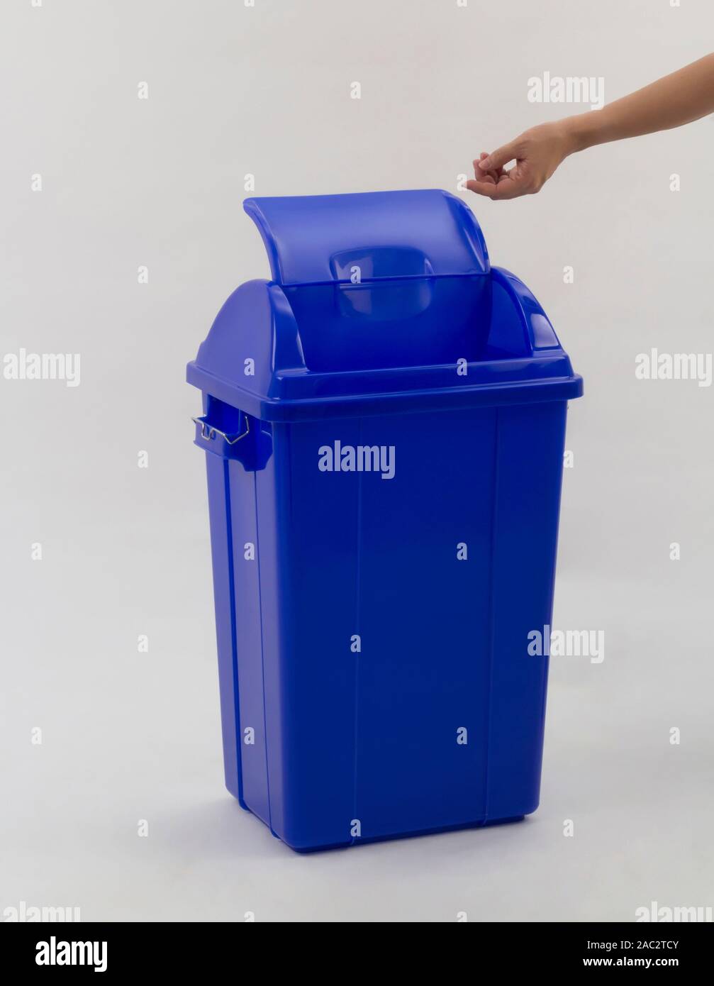woman hand throwing something into the trash can isolated on white backgound Stock Photo
