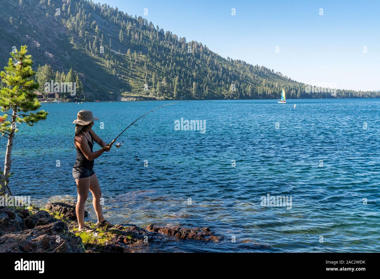 A Woman Fishing During Sunset in Lake Tahoe, Nevada Stock Photo