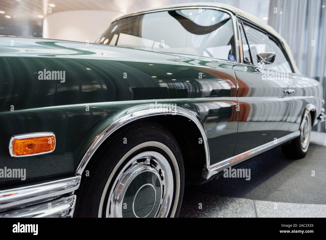 Ground level photo of left side of the green polished car standing on