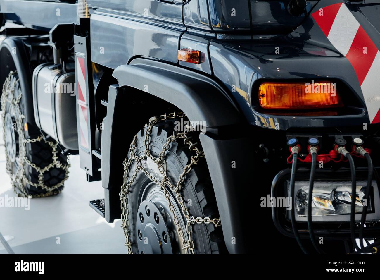 Cropped image. Right side of the car. Jeep with snow chains parked