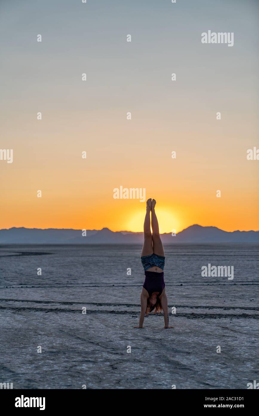 Beautiful Woman Doing Handstands During Sunset In the Bonneville Salt Flats Stock Photo
