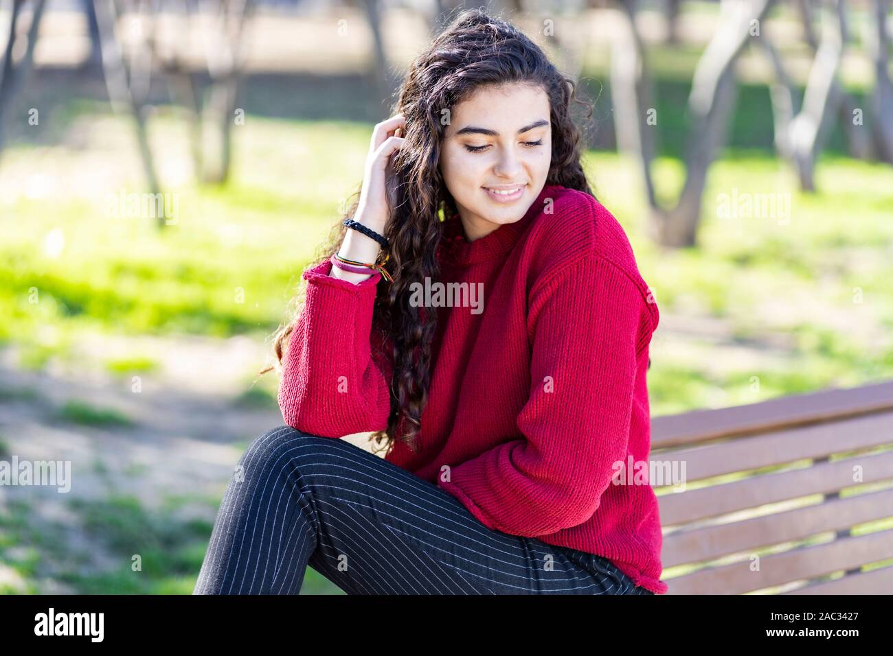 Cute young woman sitting on bench park Stock Photo - Alamy