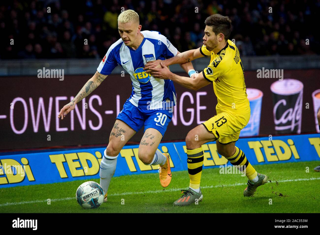 Berlin, Germany. 30th Nov, 2019. Soccer: Bundesliga, Hertha BSC - Borussia Dortmund, 13th matchday, Olympiastadion Berlin. Berlin's Marius Wolf and Dortmund's Raphael Guerreiro (r) in a duel. Credit: Gregor Fischer/dpa - IMPORTANT NOTE: In accordance with the requirements of the DFL Deutsche Fußball Liga or the DFB Deutscher Fußball-Bund, it is prohibited to use or have used photographs taken in the stadium and/or the match in the form of sequence images and/or video-like photo sequences./dpa/Alamy Live News Stock Photo