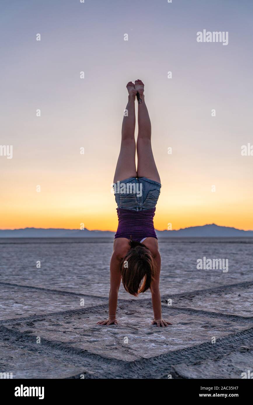 Beautiful Woman Doing Handstands During Sunset In the Bonneville Salt Flats Stock Photo