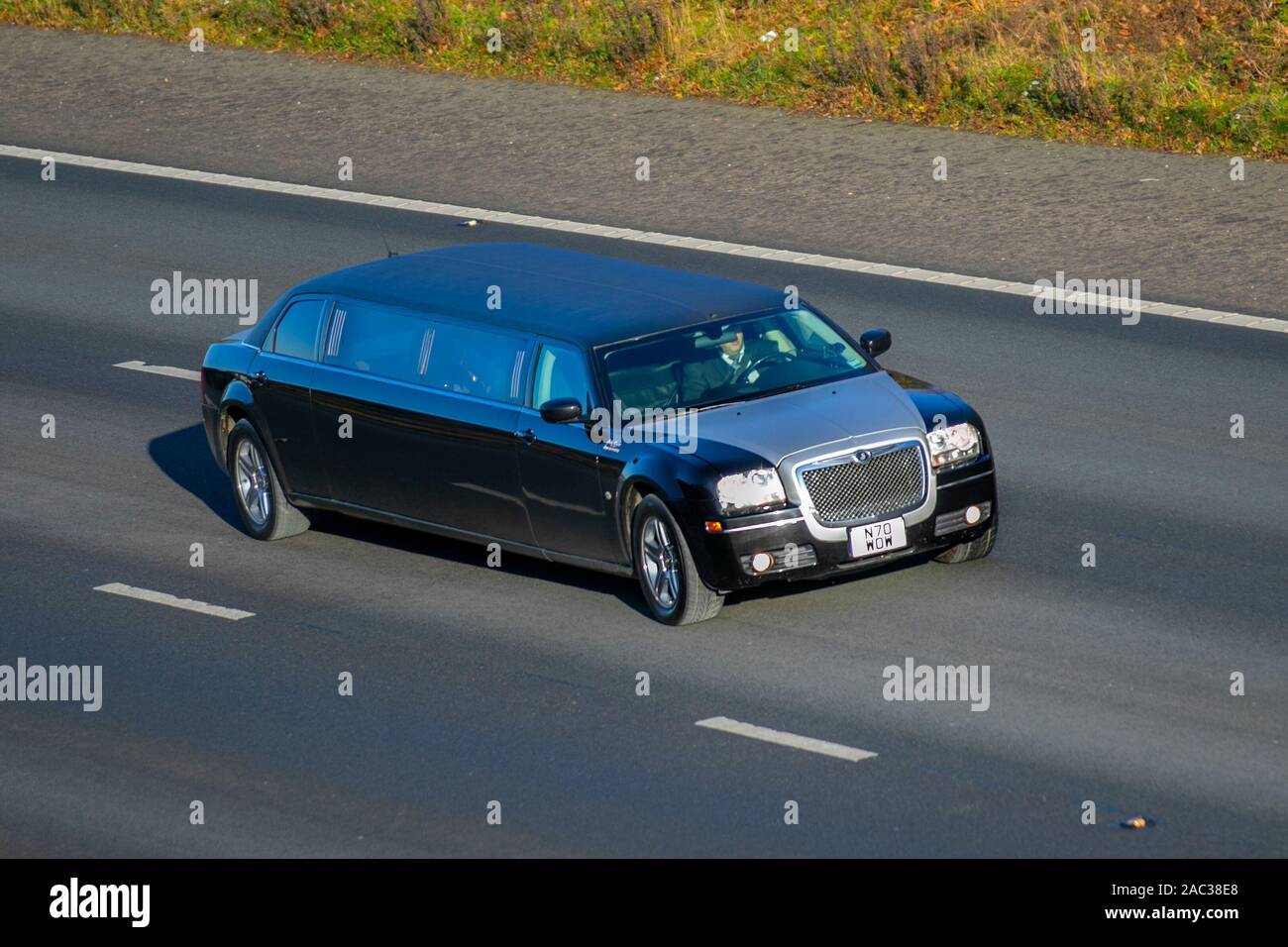 2009 Chrysler stretched large luxury vehicle; UK Vehicular traffic, transport, modern vehicles, saloon cars, vehicles, vehicle, uk roads, motors, motoring south-bound on the 3 lane M61 motorway highway Stock Photo