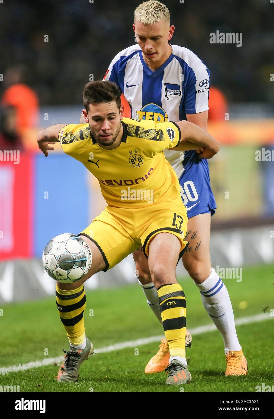 Berlin, Germany. 30th Nov, 2019. Soccer: Bundesliga, Hertha BSC - Borussia Dortmund, 13th matchday, Olympic Stadium. Raphael Guerreiro of Borussia Dortmund (l) fights against Berlin's Marius Wolf for the ball. Credit: Andreas Gora/dpa - IMPORTANT NOTE: In accordance with the requirements of the DFL Deutsche Fußball Liga or the DFB Deutscher Fußball-Bund, it is prohibited to use or have used photographs taken in the stadium and/or the match in the form of sequence images and/or video-like photo sequences./dpa/Alamy Live News Stock Photo