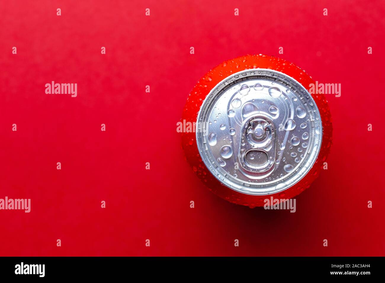 Beverages soda can with condensation drops over red background with place for text Stock Photo