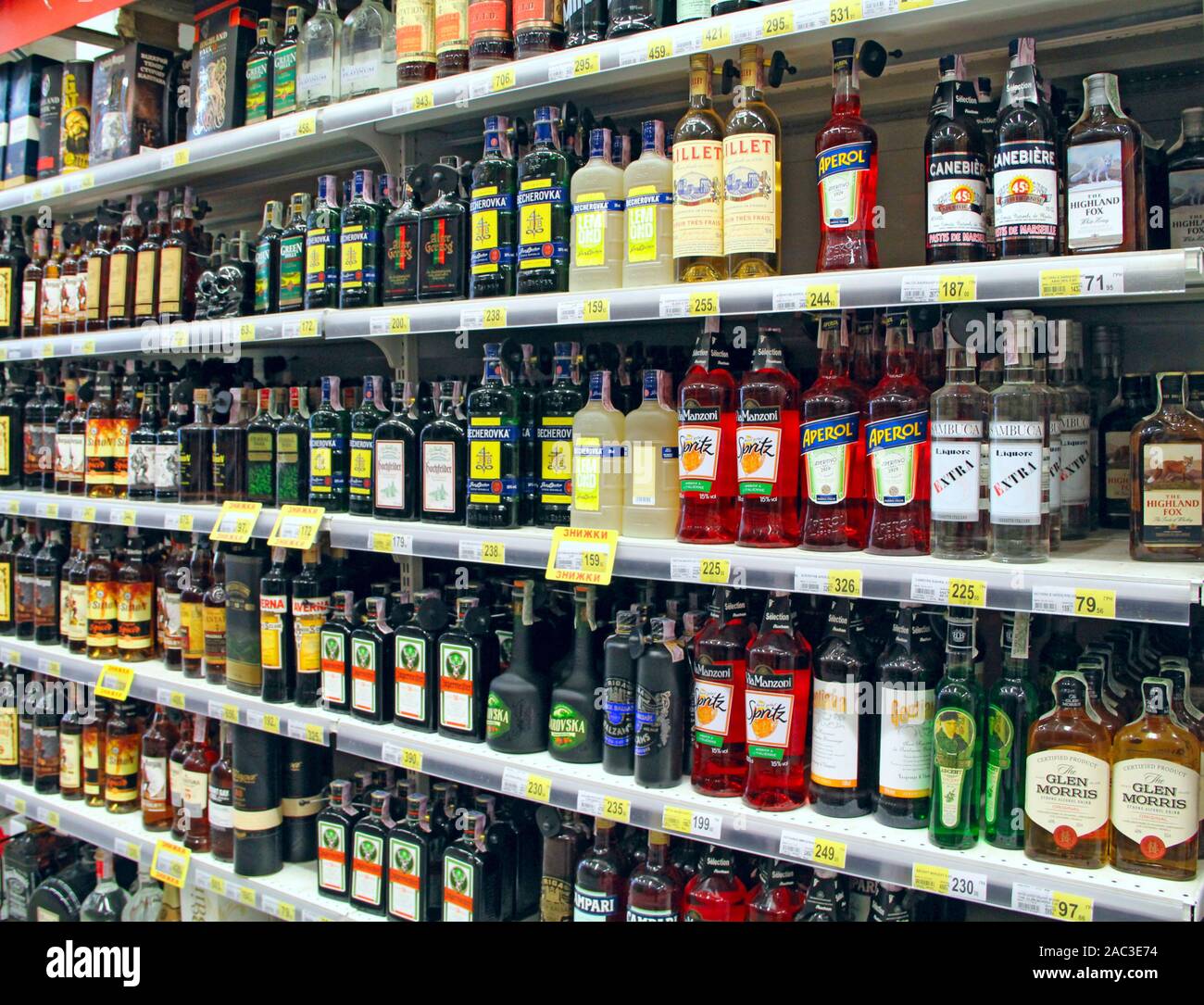 Cognacs, vodka, liqueurs, and other alcoholic beverages on supermarket shelves. Wide selection of alcoholic drinks in bottles in shop. Alcoholic drink Stock Photo