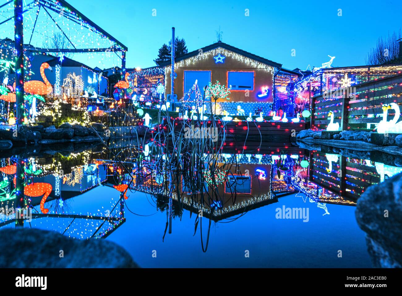 Berg Bei Ravensburg, Germany. 30th Nov, 2019. The illuminated garden and the house of the Schlagmüller family are reflected in the goldfish pond at the blue hour. Thousands of lights illuminate the garden of the Schlagmüller family. Credit: Felix Kästle/dpa/Alamy Live News Stock Photo