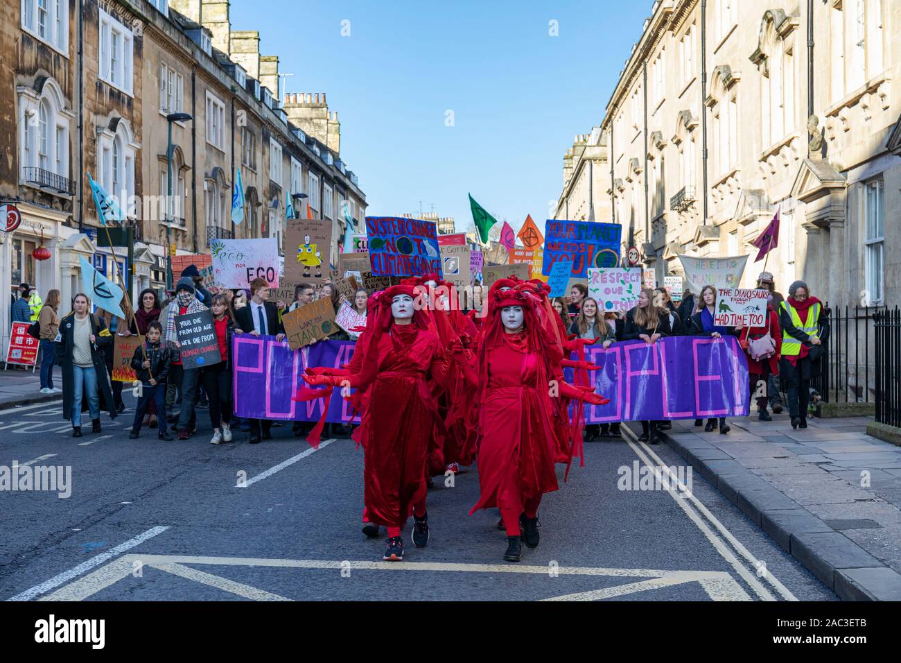 Extinction Rebellion Red Brigade climate change protesters march through Bath City centre with Bath Youth Climate Alliance campaigning for action. UK Stock Photo