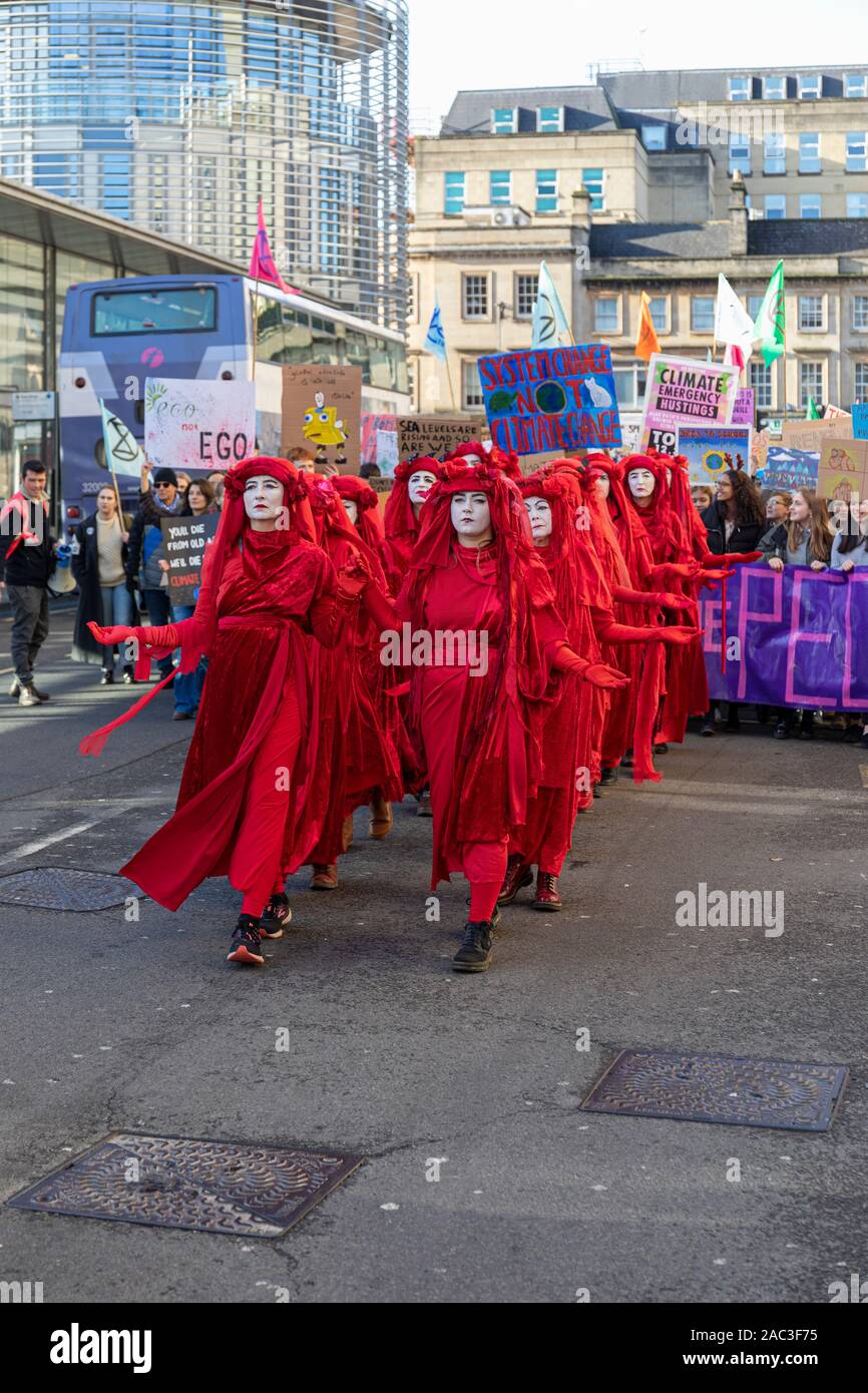 Extinction Rebellion Red Brigade climate change protesters march through Bath City centre with Bath Youth Climate Alliance campaigning for action. UK Stock Photo