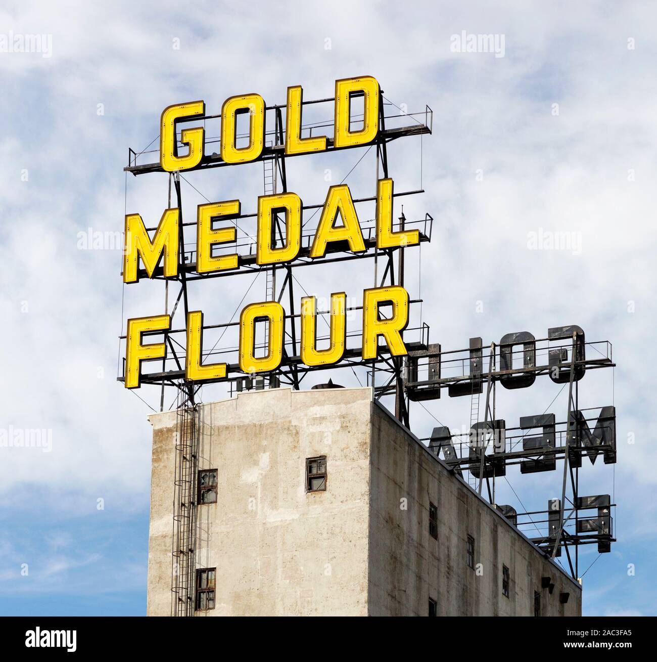 The yellow Gold Medal Flour neon signs on top of grain elevators which are now part of historic Mill City Museum in downtown Minneapolis, Minnesota Stock Photo